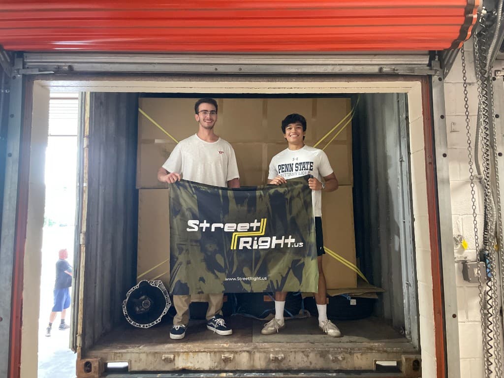 StreetRight team holding a StreetRight.us banner inside a shipping container